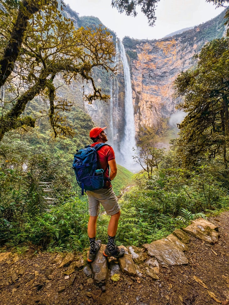 A man standing in front of a waterfall