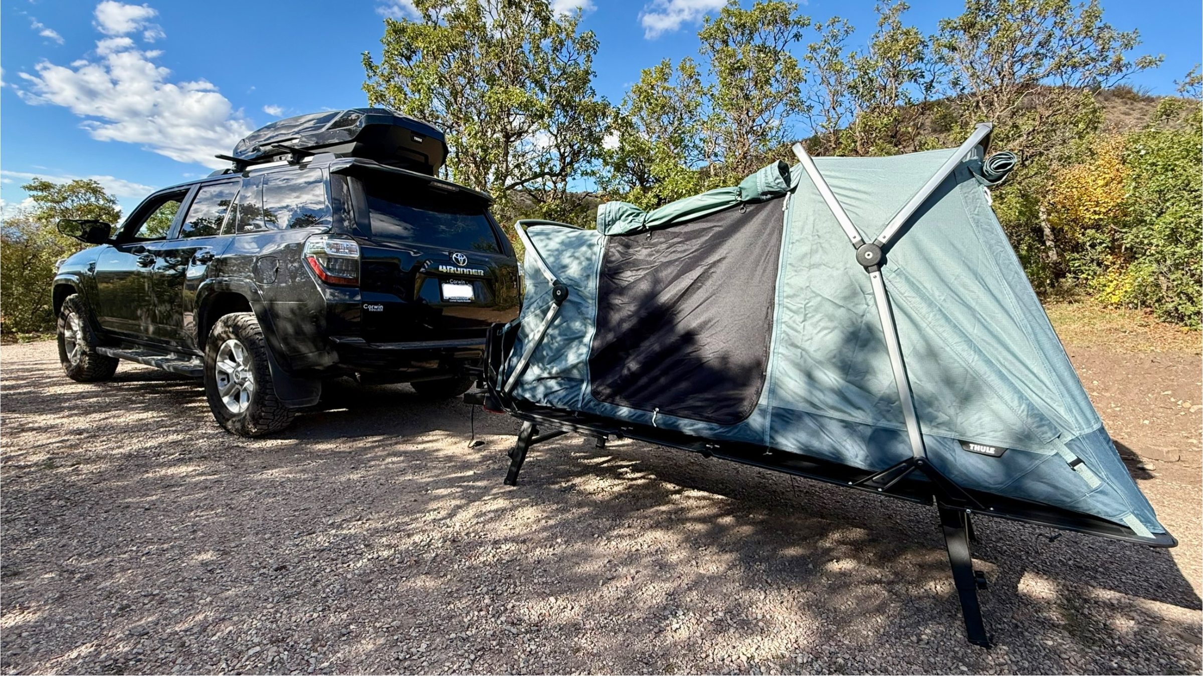 black Toyota 4Runner parked outside with Thule Outset hitch-mounted car tent set up behind it