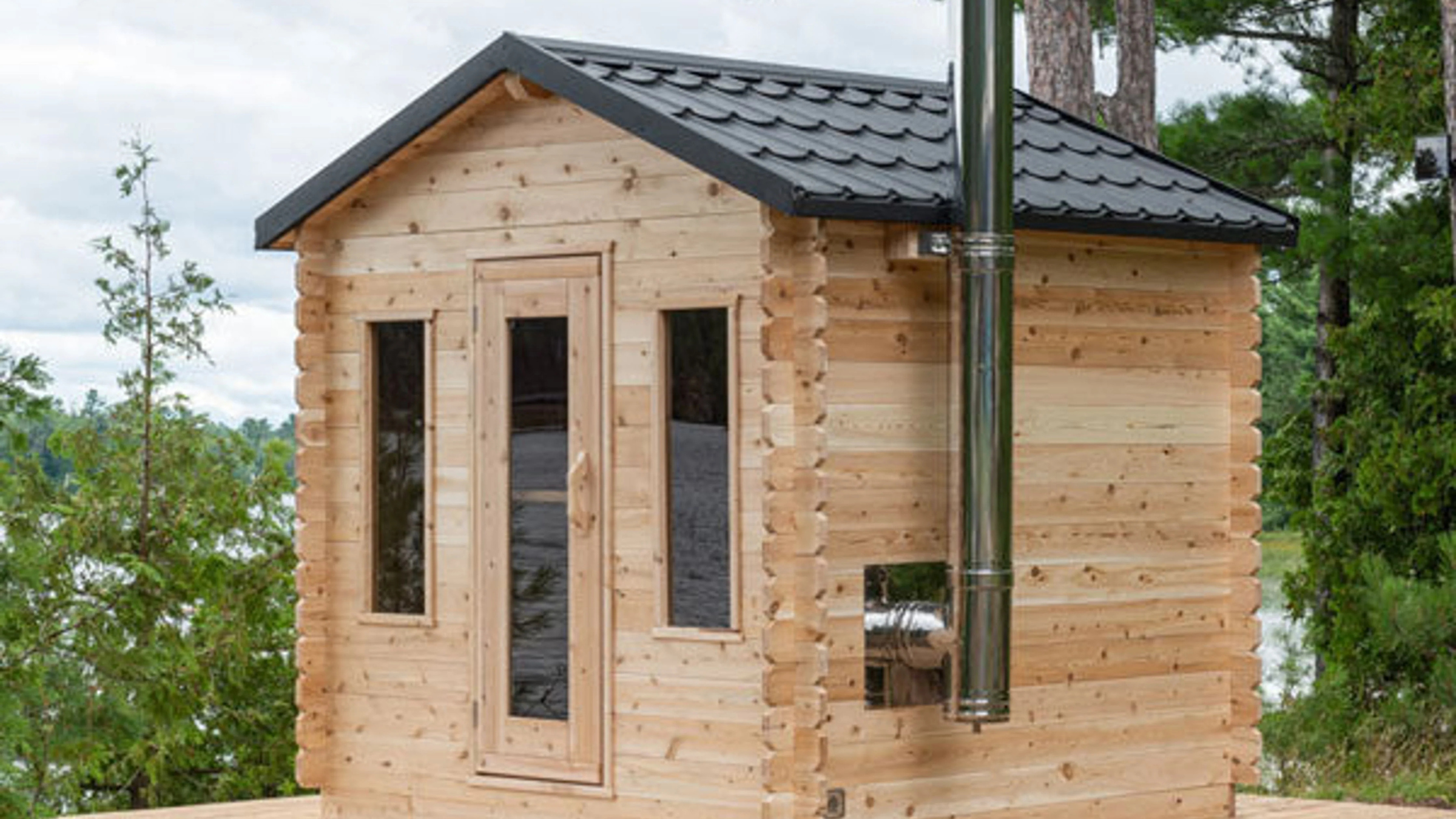 cabin-style wood-burning home sauna from LeisureCraft with trees surrounding it
