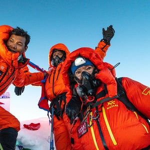 carlos soria and two other climbers standing atop manaslu