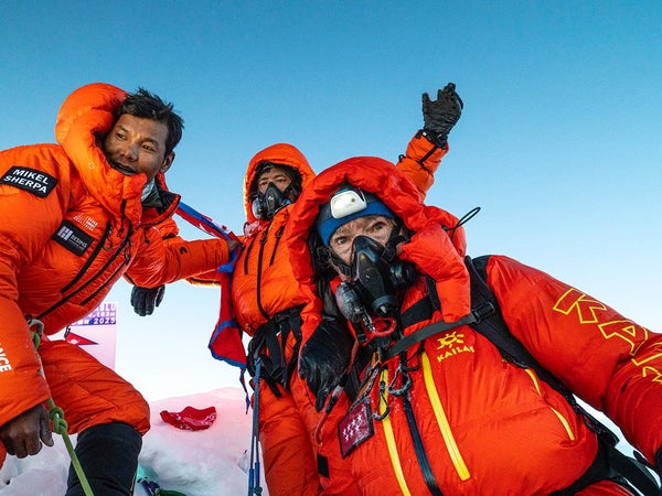 carlos soria and two other climbers standing atop manaslu