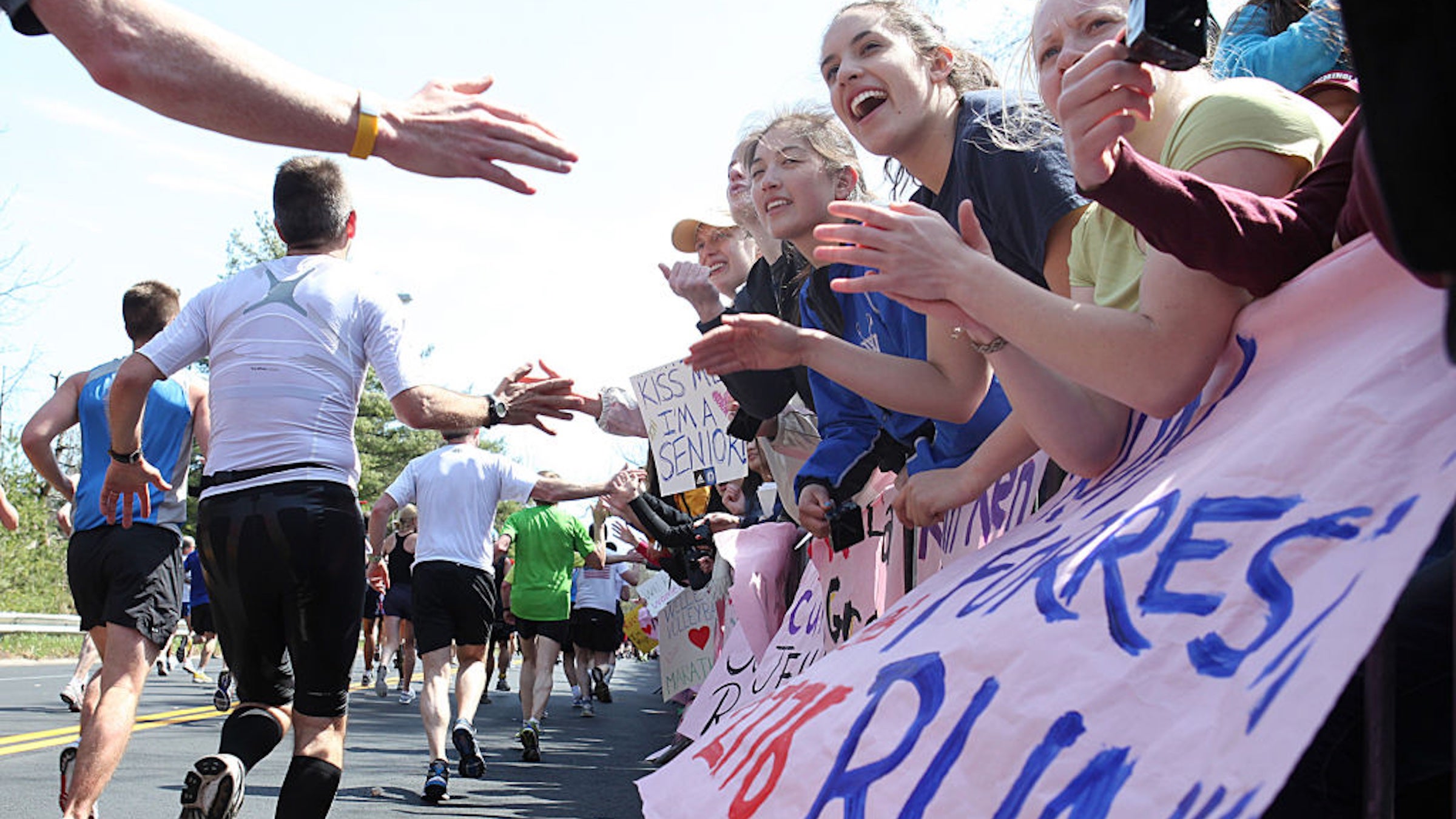 Runners make their way past cheering Wellesley College students during the 115th Boston Marathon