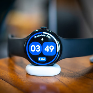 Google Pixel Watch 4 charging on a nightstand