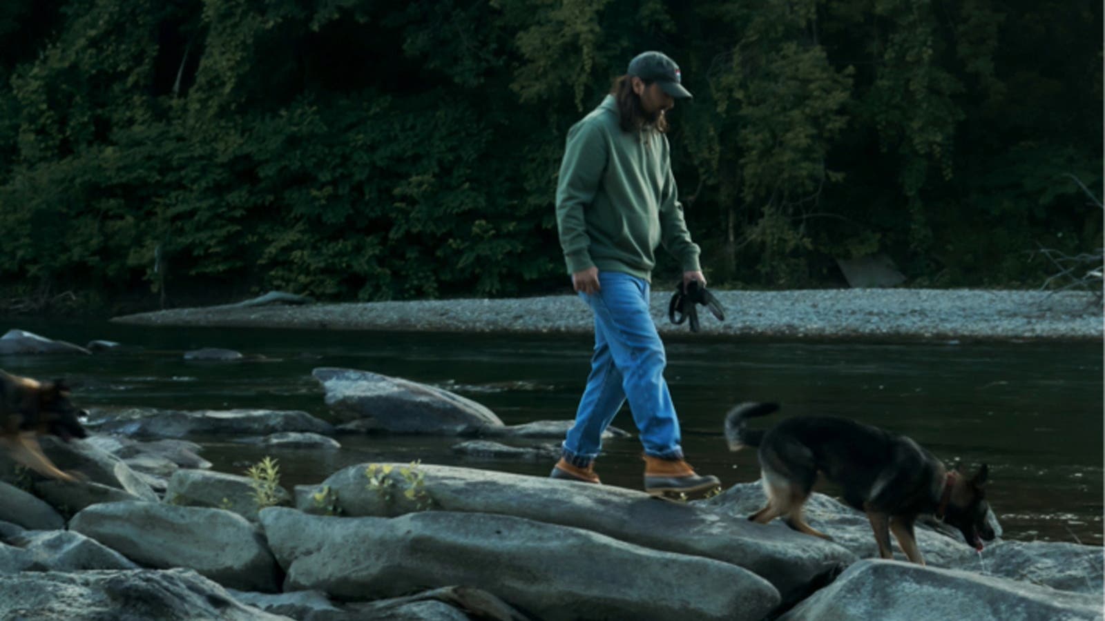 noah kahan wearing ll bean in the woods walking on a rock