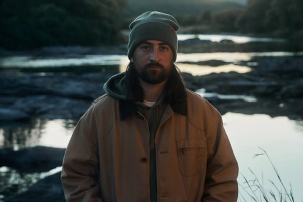 Noah Kahan wearing LL Bean by a river
