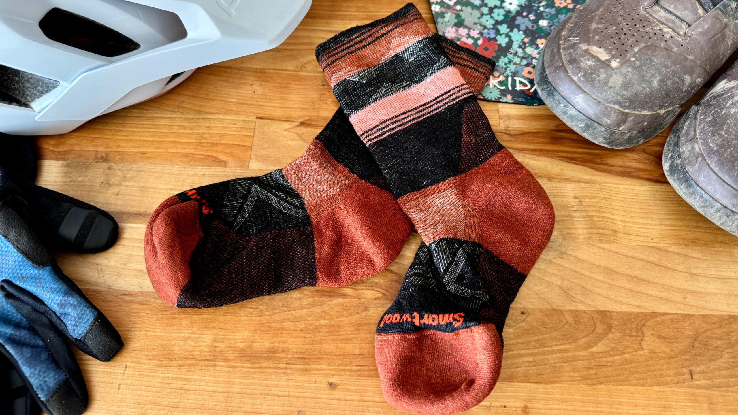 striped smartwool socks on a table next to helmet and gloves mountain bike gear under $50