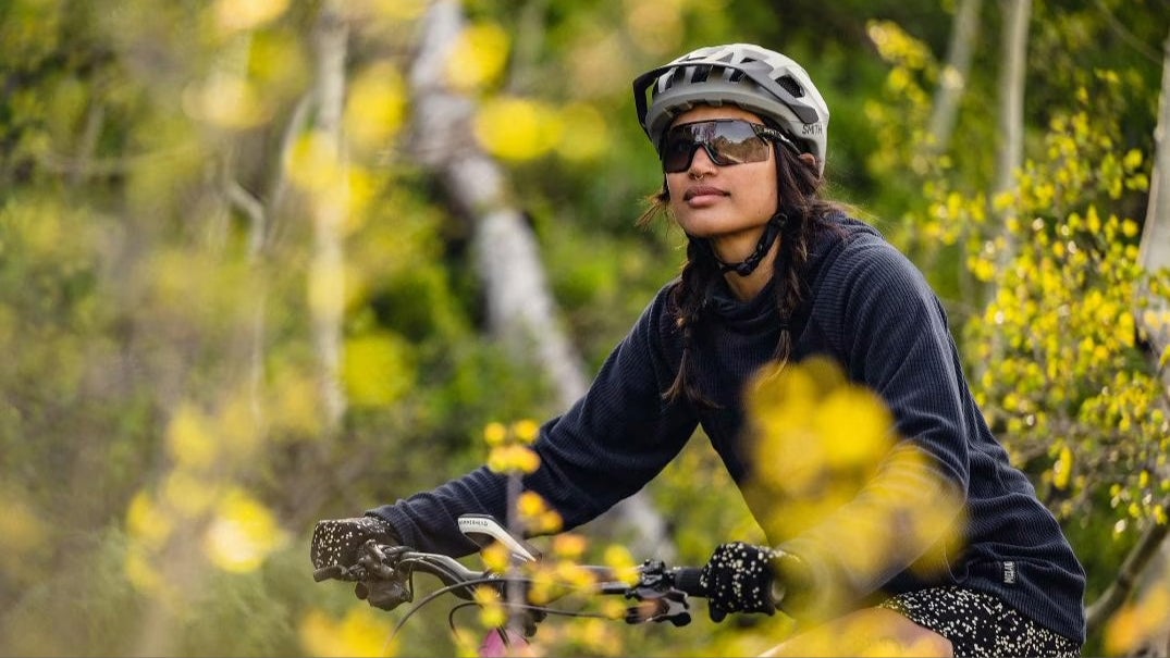 girl wearing smith sunglasses on a bike, using products bought at the 2025 Evo Anniversary Sale