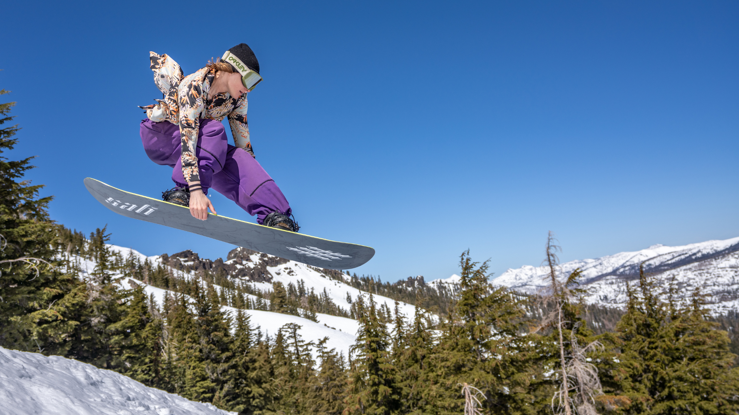 female snowboarder catching air at kirkwood