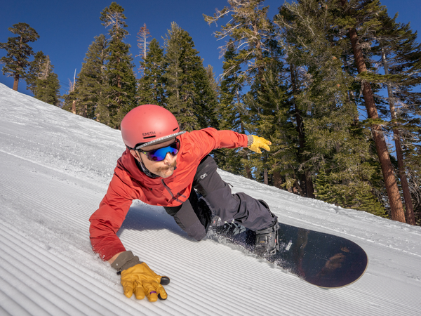 snowboarder leans into turn on corduroy