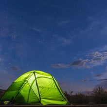 A bright green Northface Stormbreak 2 Tent beneath a starry sky in Chaco Canyon