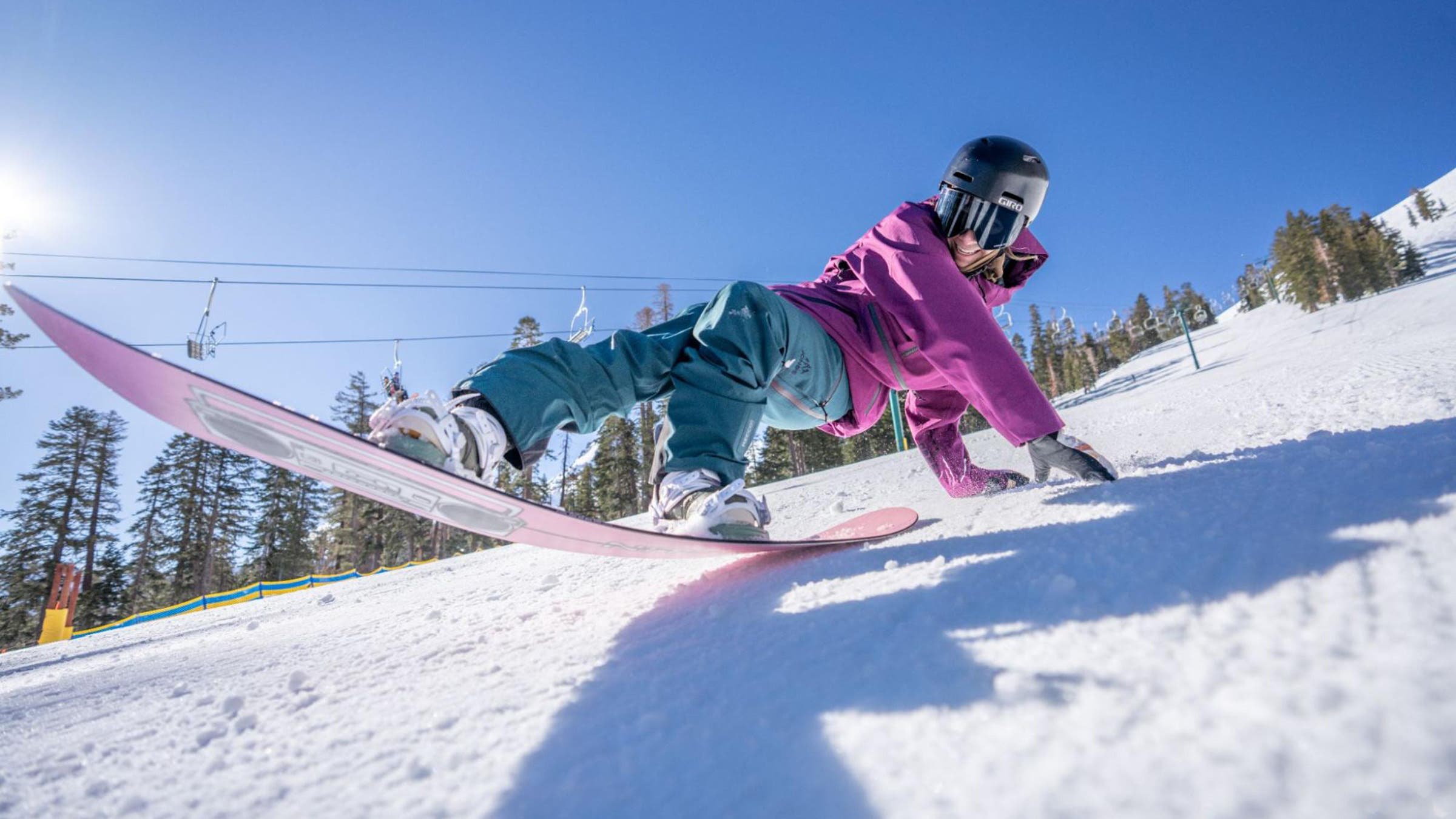Woman snowboarder in purple jacket testing a women's snowboard at the Outside Snowboard Test at Kirkwood