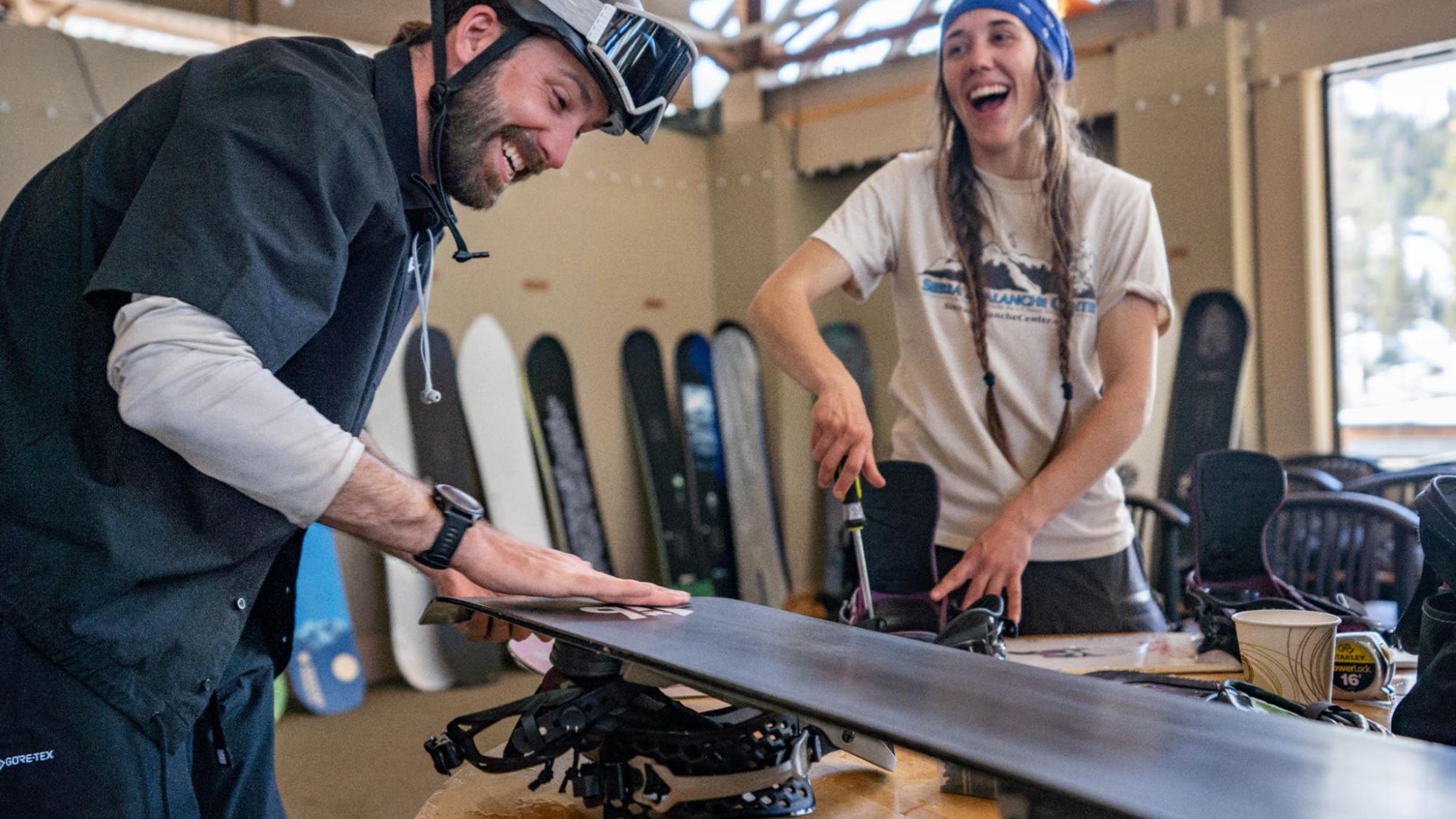 Two snowboarders tuning and adjusting snowboards at Outside's Snowboard Test at Kirkwood