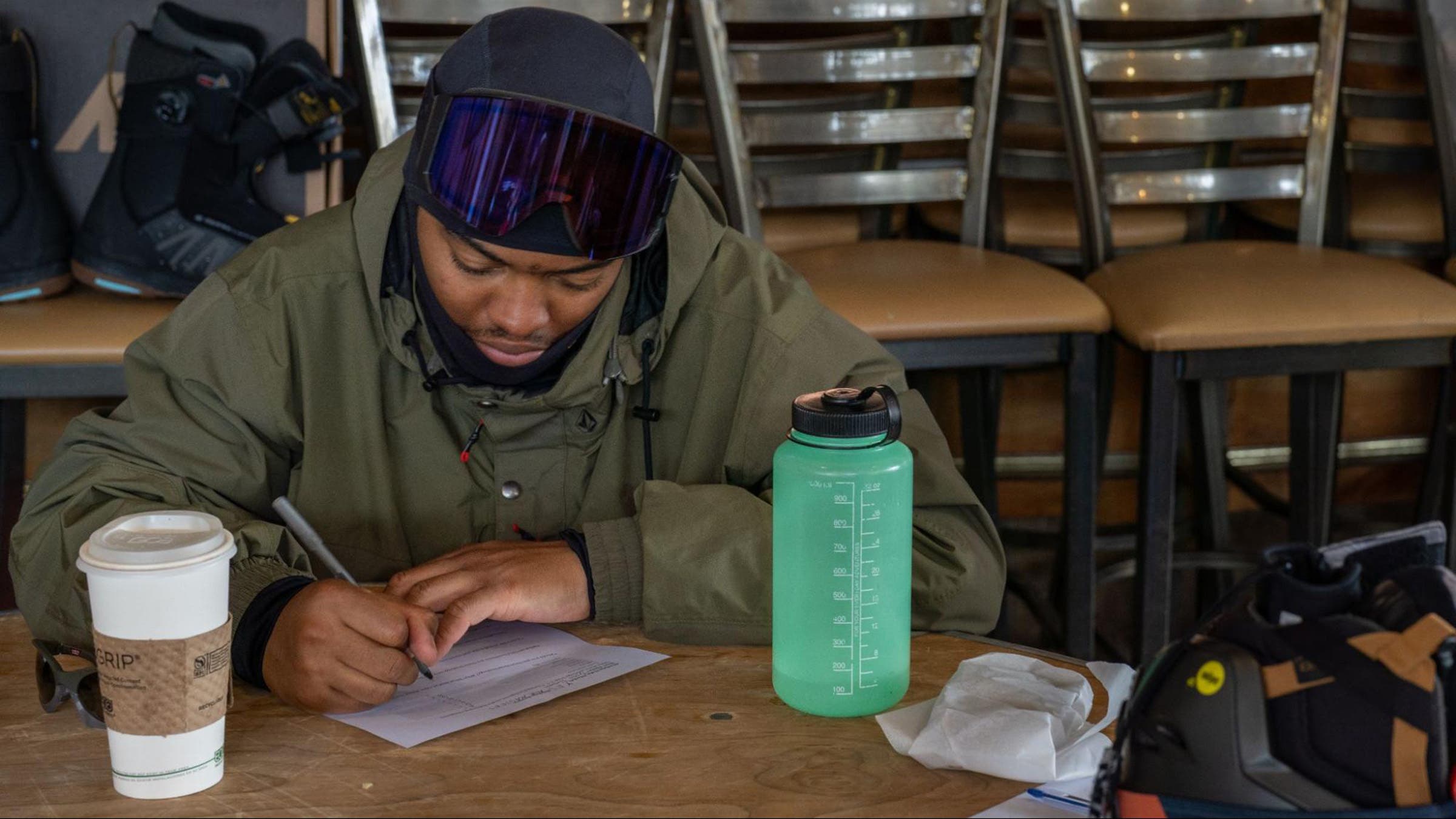 Snowboarder sitting at table indoors filling out review form during Outside's Snowboard Test