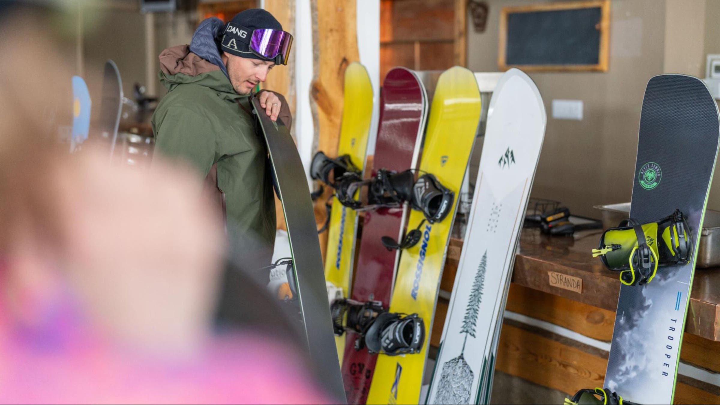 Snowboarder selecting a snowboard to test from lineup