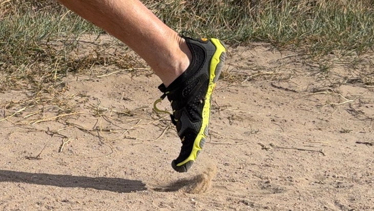 foot wearing Vibram FiveFingers pushing off on a dirt trail