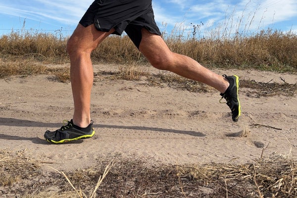 runner's legs in full stride on a trail wearing Vibram FiveFingers