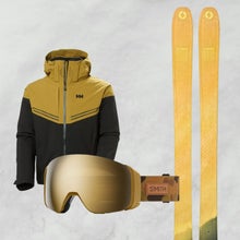 Yellow, black, and gold skis, ski gloves, goggles and ski jacket on white snowy background