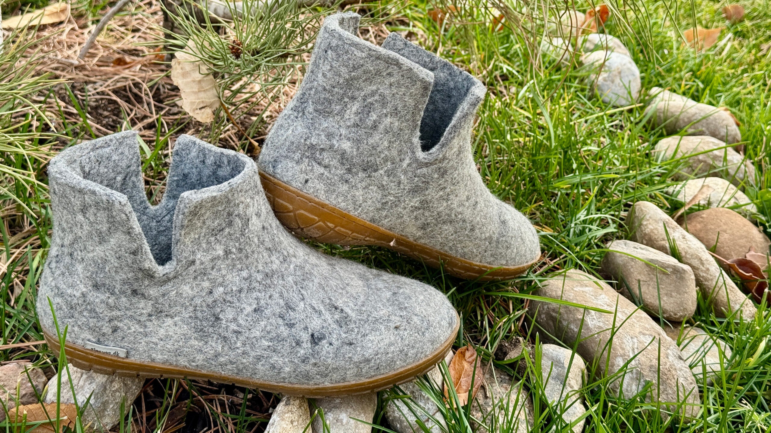 Closeup of grey Glerups wool boot slippers on grass