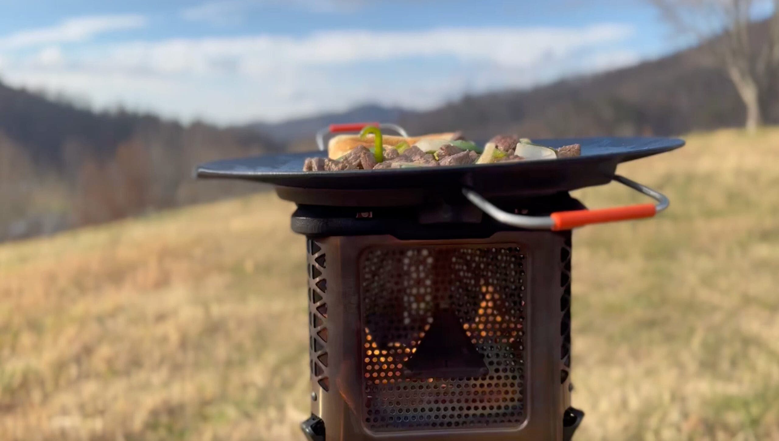 Closeup of Ignik Skullet cook stove set up in field for tailgating
