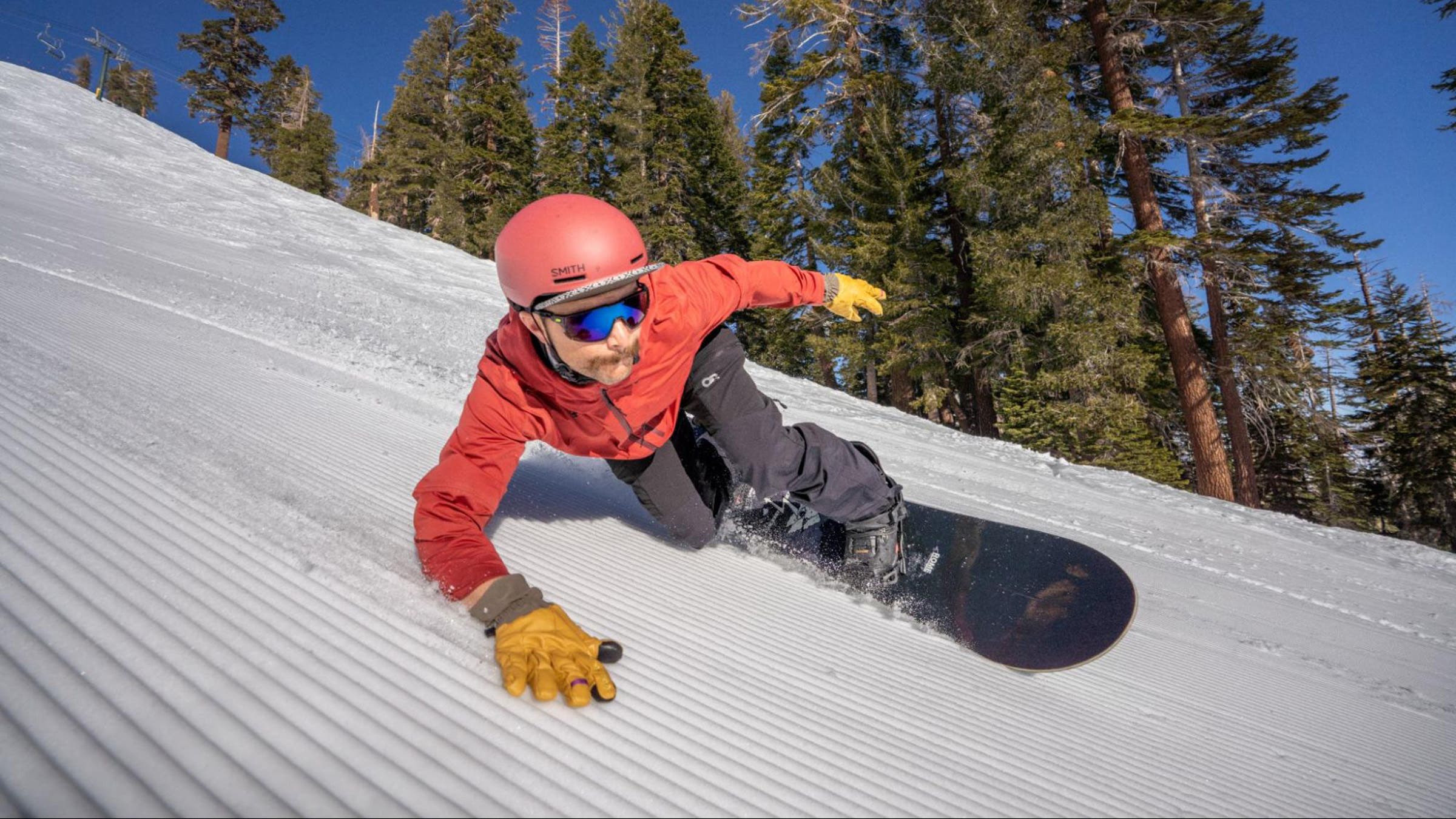 snowboarder leans into turn on corduroy