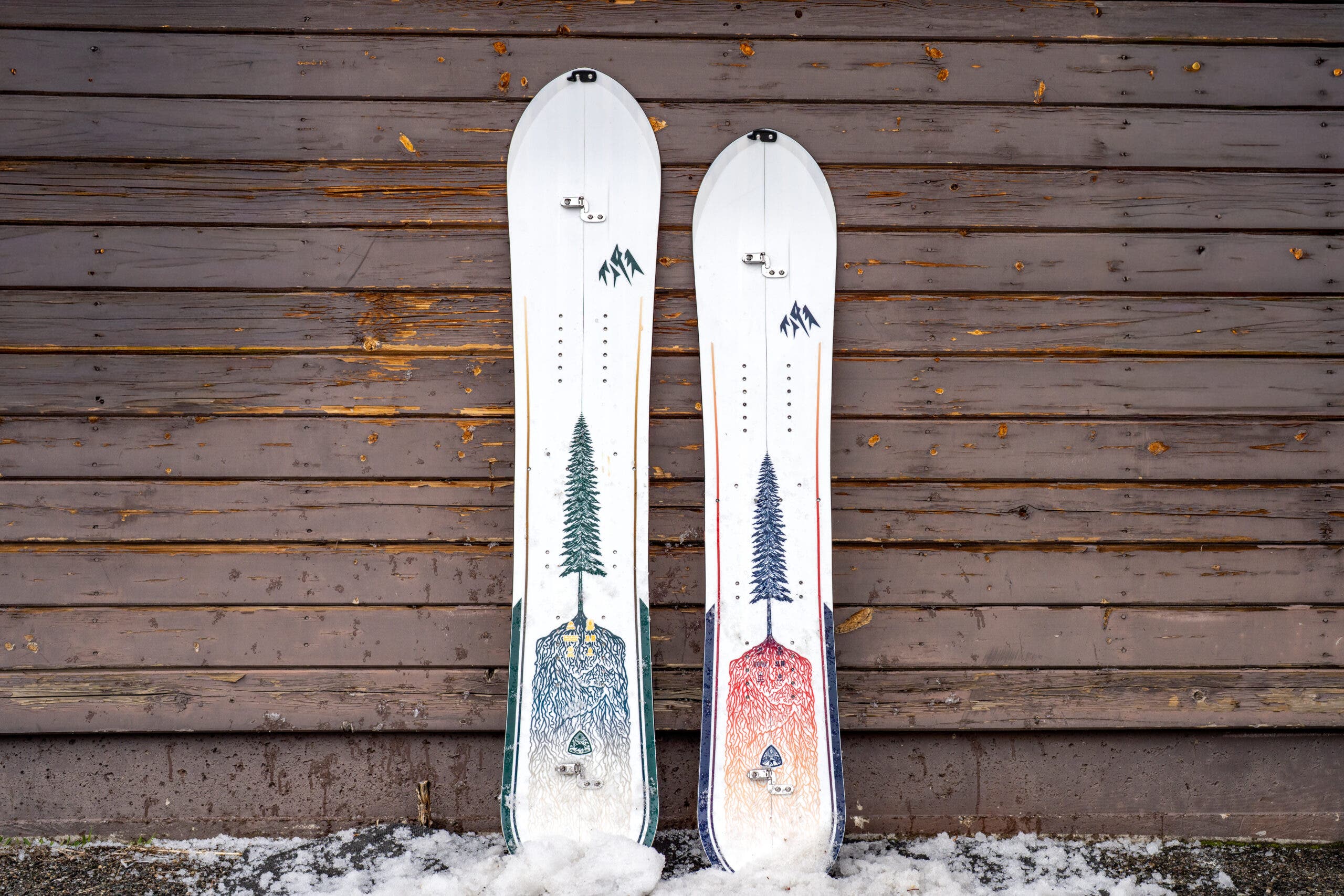 Jones Frontier and Dream Weaver splitboards leaning against weathered building