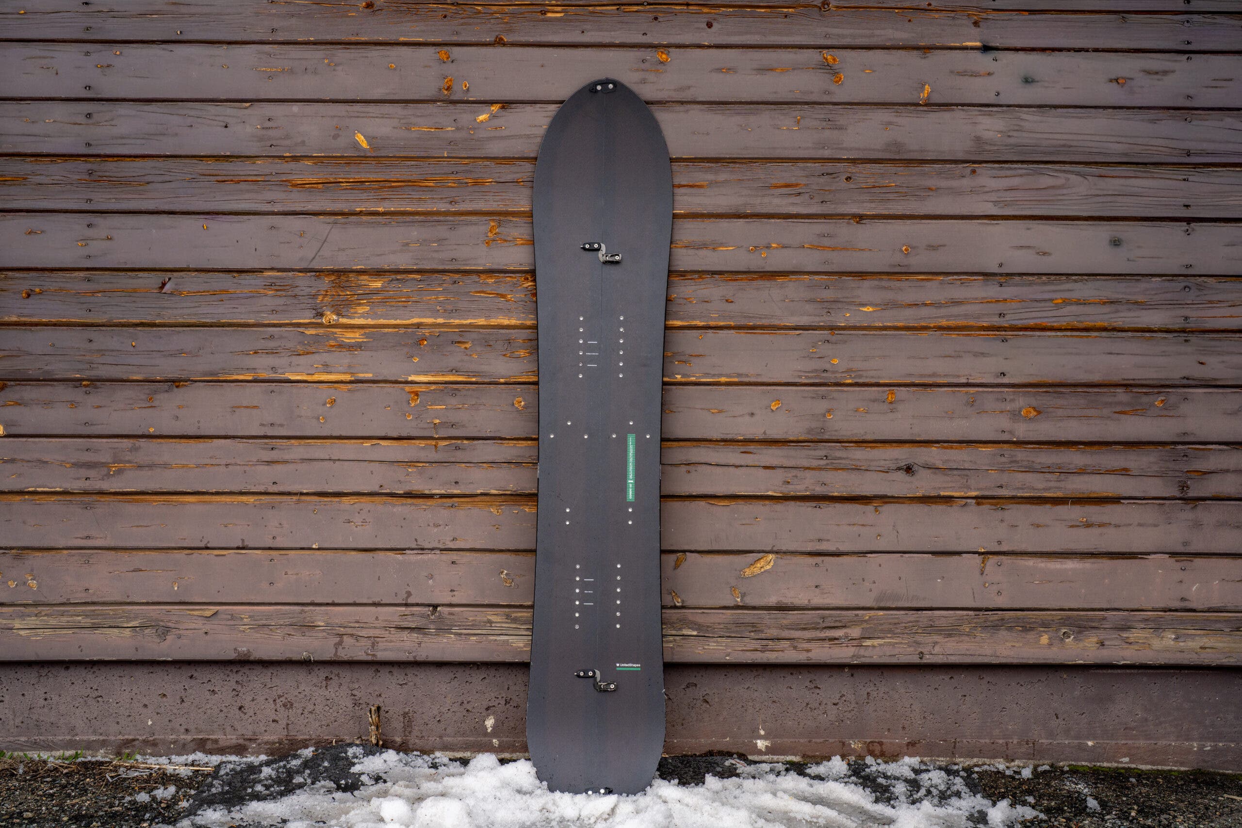 United Shapes Covert splitboard leaning against weathered building