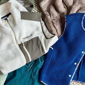 Closeup of women's vests piled on rug