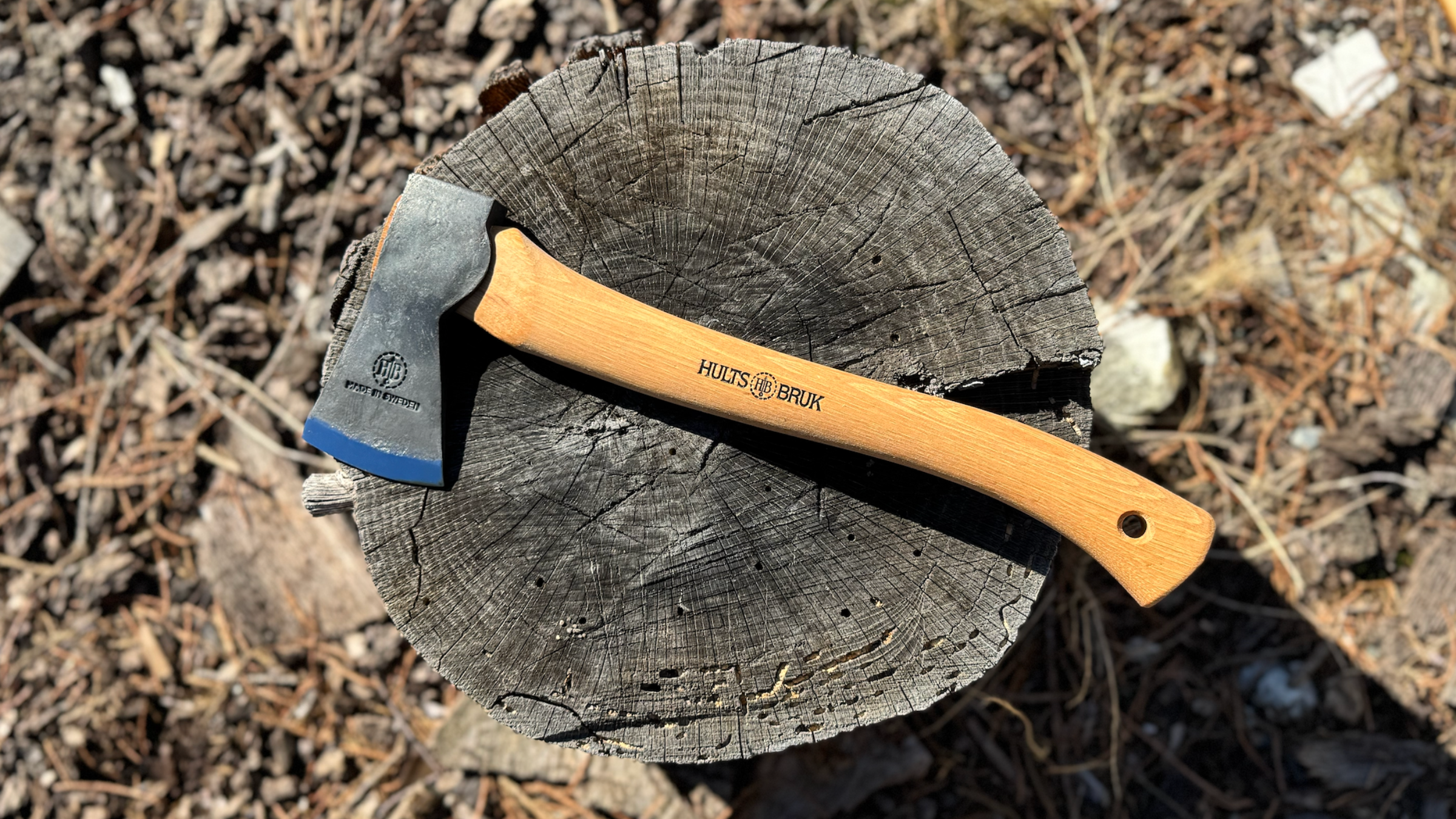 wooden-handled hatchet on top of tree stump outside from Hults Bruk