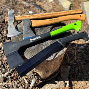 four best hatchets of various styles resting on wooden stump outside