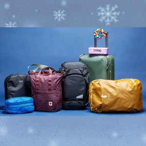 best travel gifts 2025 showing several pieces of colorful duffel bags and carry on luggage on a blue background