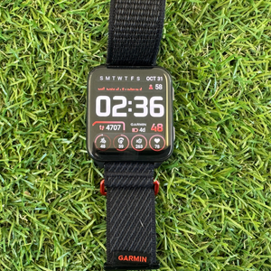 Garmin Venu X1 smart watch with black wrist band displayed on grassy background