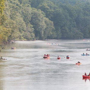 people kayaking down a river