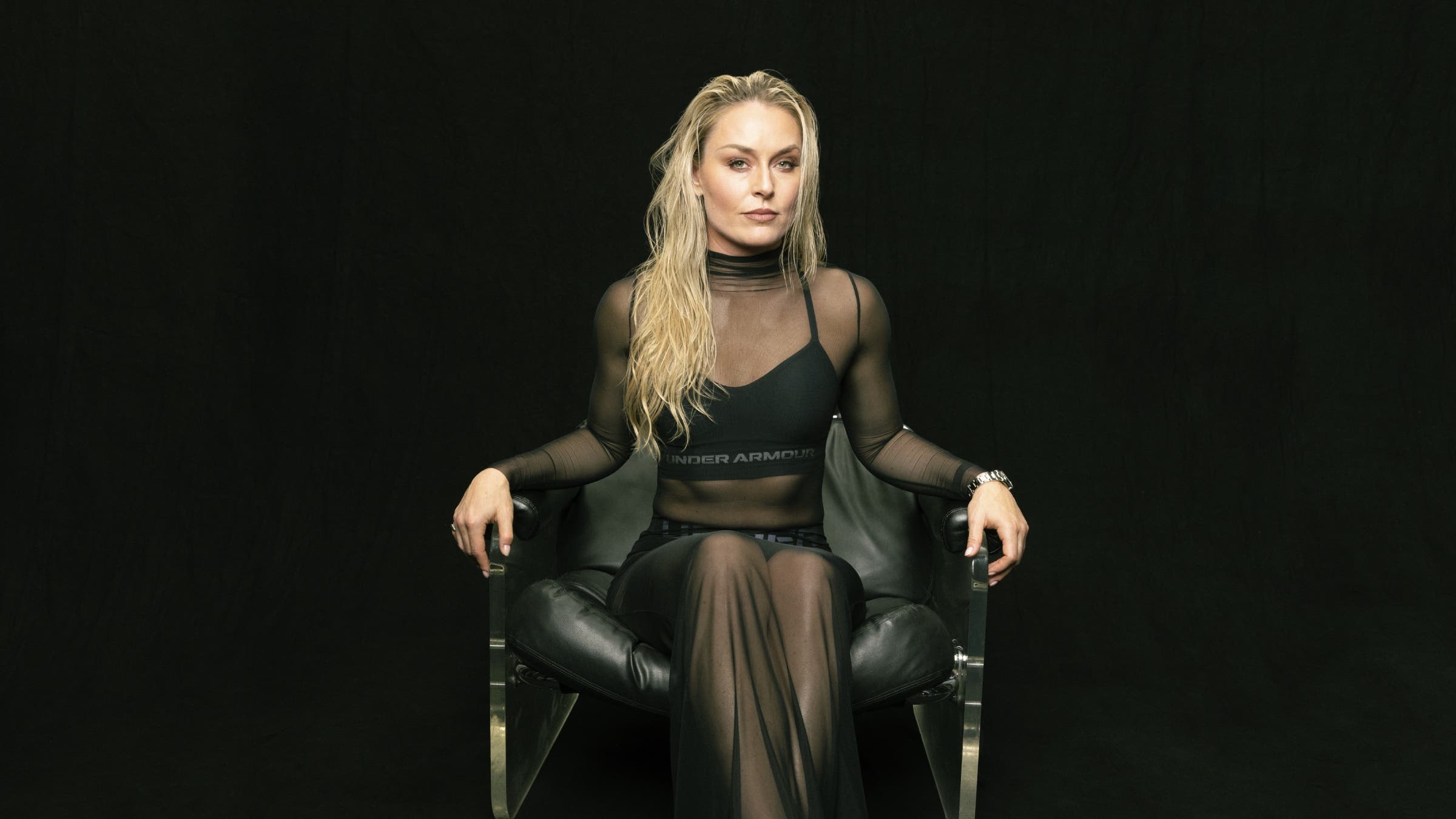 Lindsey Vonn sits in a leather chair against a black background