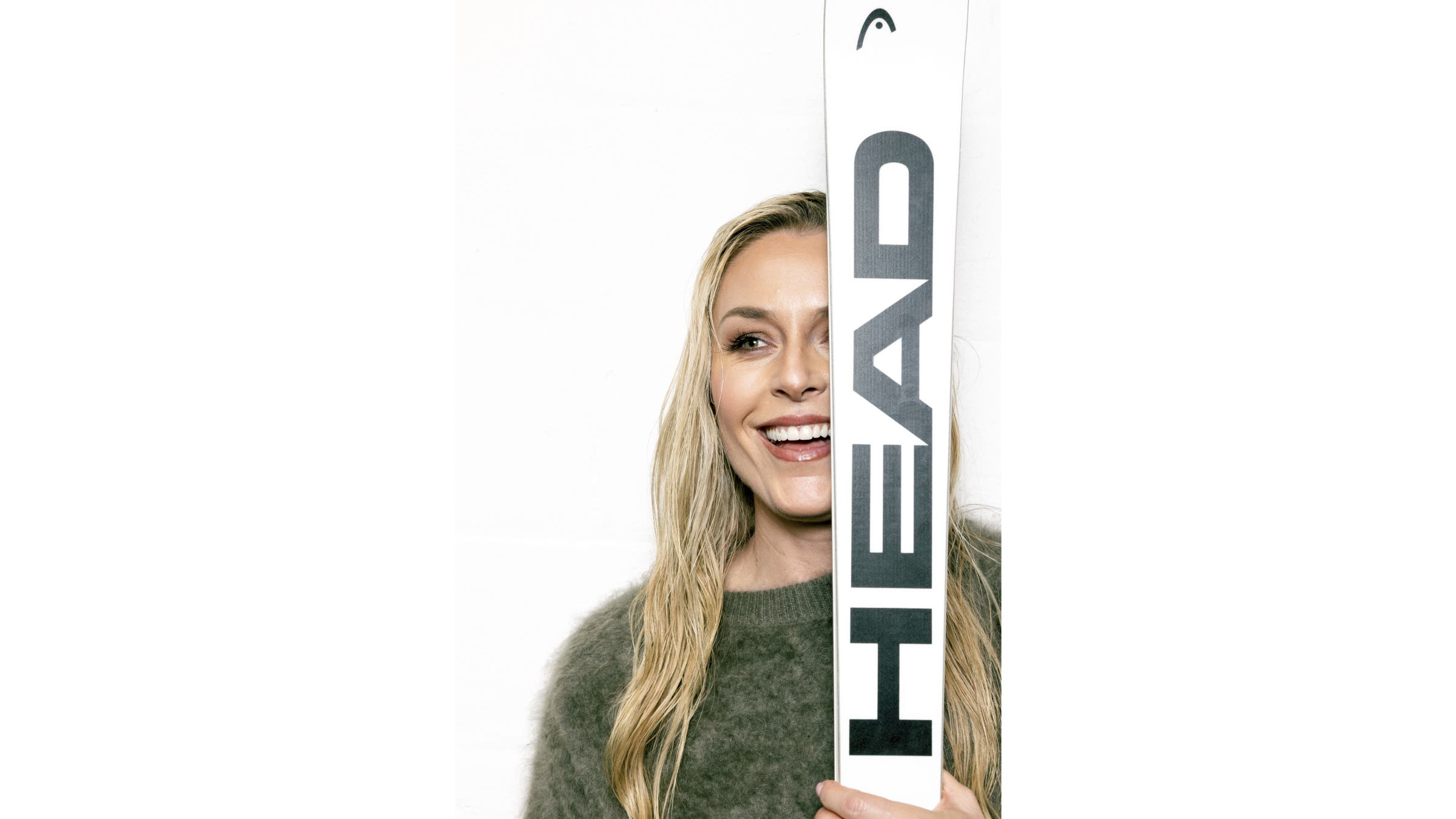 Lindsey Vonn smiles while holding a ski over her face