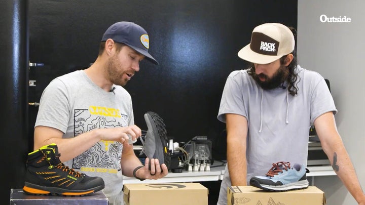 Adam Roy and Adam Trenkamp looking at the tread on hiking shoes in the Outside Lab