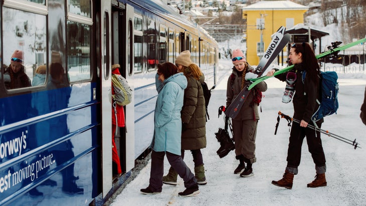 Passengers and skiers board a winter night train