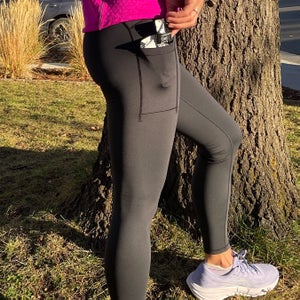 woman in winter running tights showing phone/gel pocket