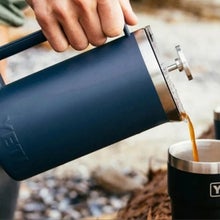 man pouring yeti french press into black yeti tumbler