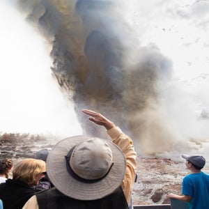 A crowd of people witness the rare eruption of Steamboat Geyser, the largest active geyser in the world