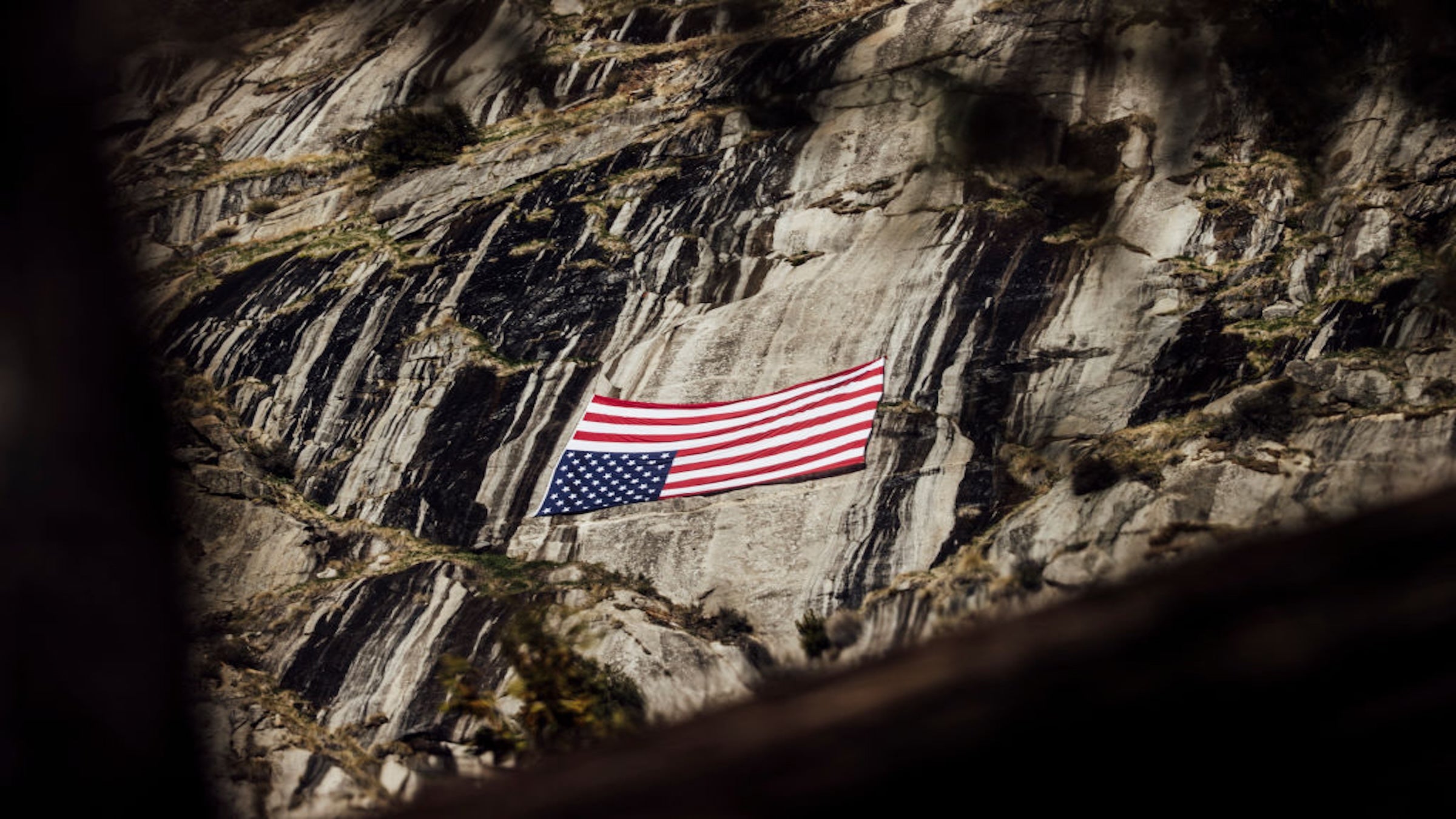 An inverted U.S. flag, a symbol of distress, is seen near Upper Yosemite Fall during a national day of action against Trump administration’s mass firing of National Park Service employees at Yosemite National Park