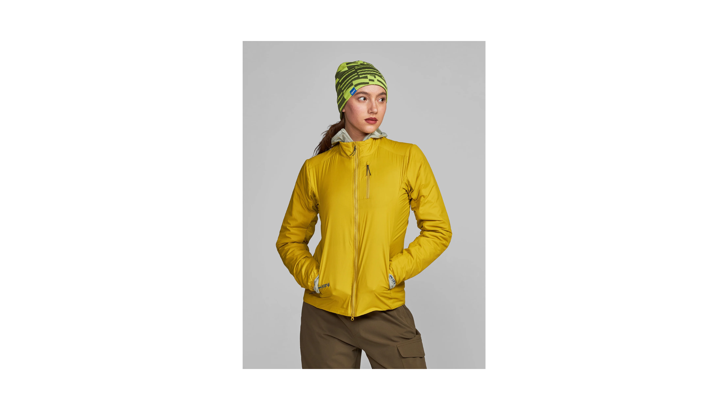 2026 Best Winter Running Jacket for Cold and Damp, the Janji ThermalRunner Insulated Jacket, as tested by Outside. Shown on a female model in mustard gold yellow