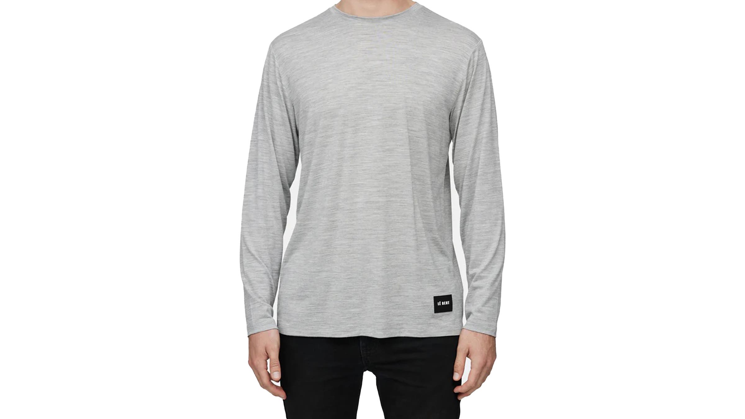 A person wearing a Le Bent Ultralight Long Sleeve Tee gray shirt on a white background