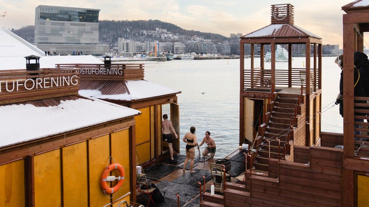 Sauna goers walk in and out of saunas to plunge in the cold waters.