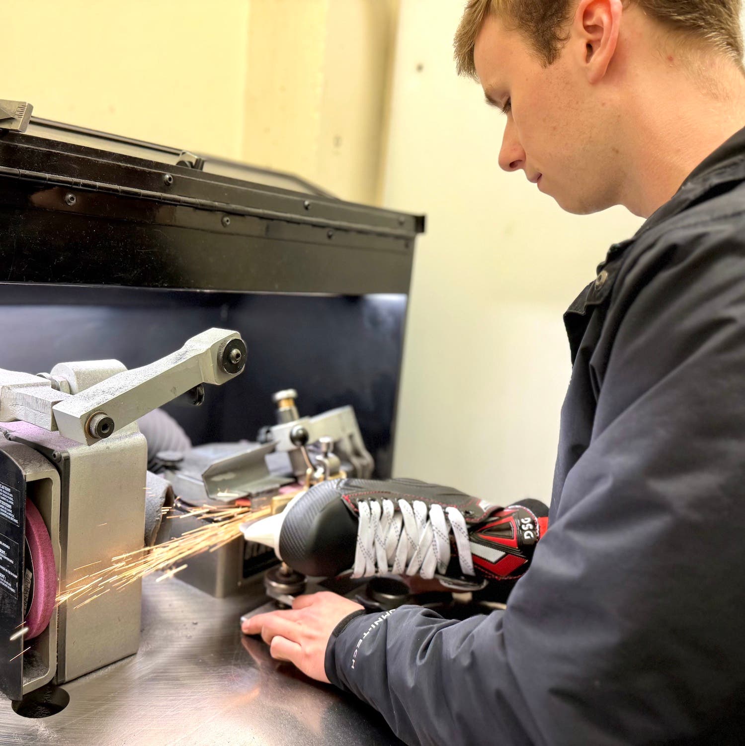 Liam sharpens hockey skates.