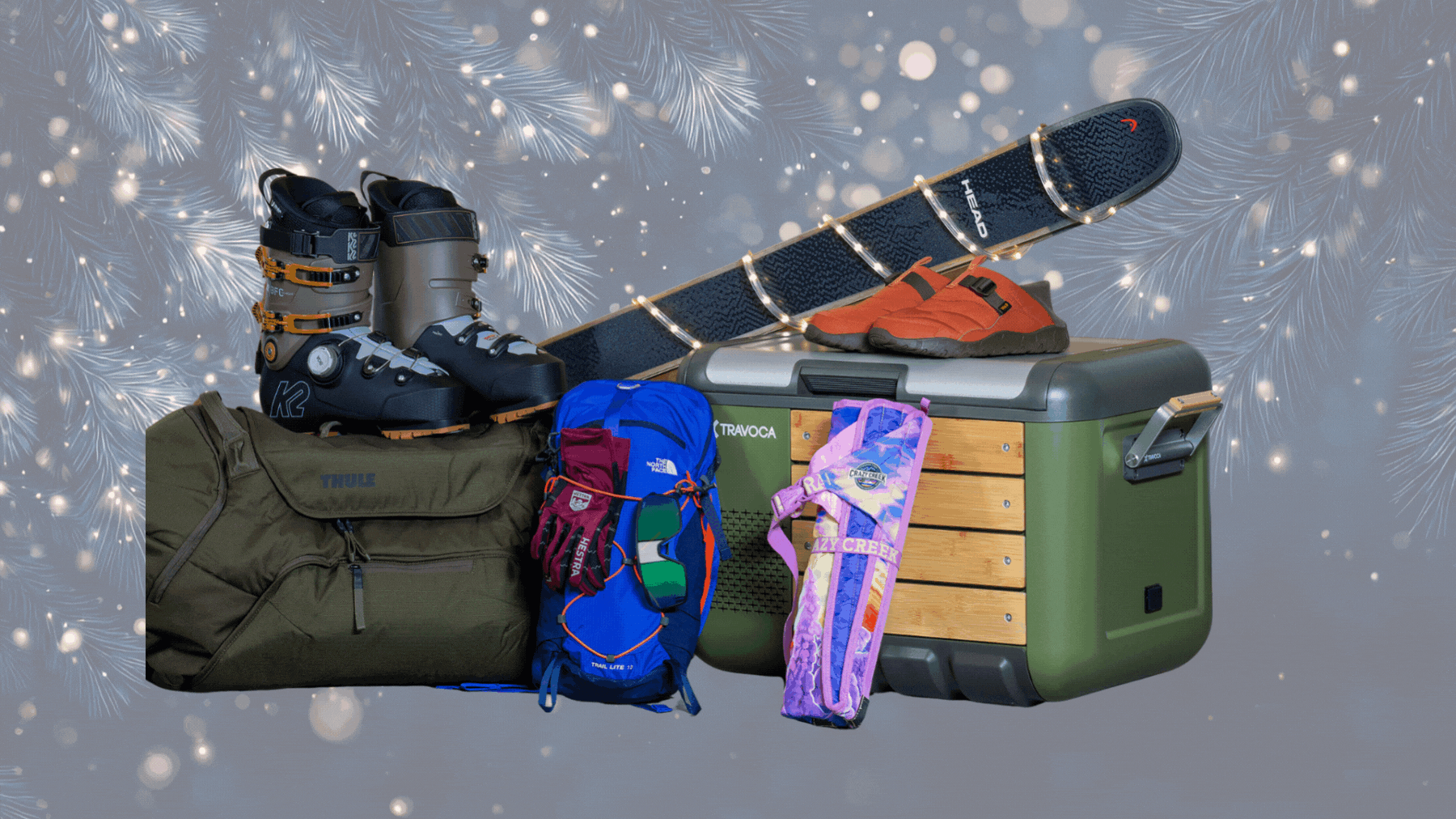 Outdoor gifts and gear, including a duffel, a cooler, ski boots, a pack, and skis wrapped in festive lights, on top of a background of twinkling lights in a forest
