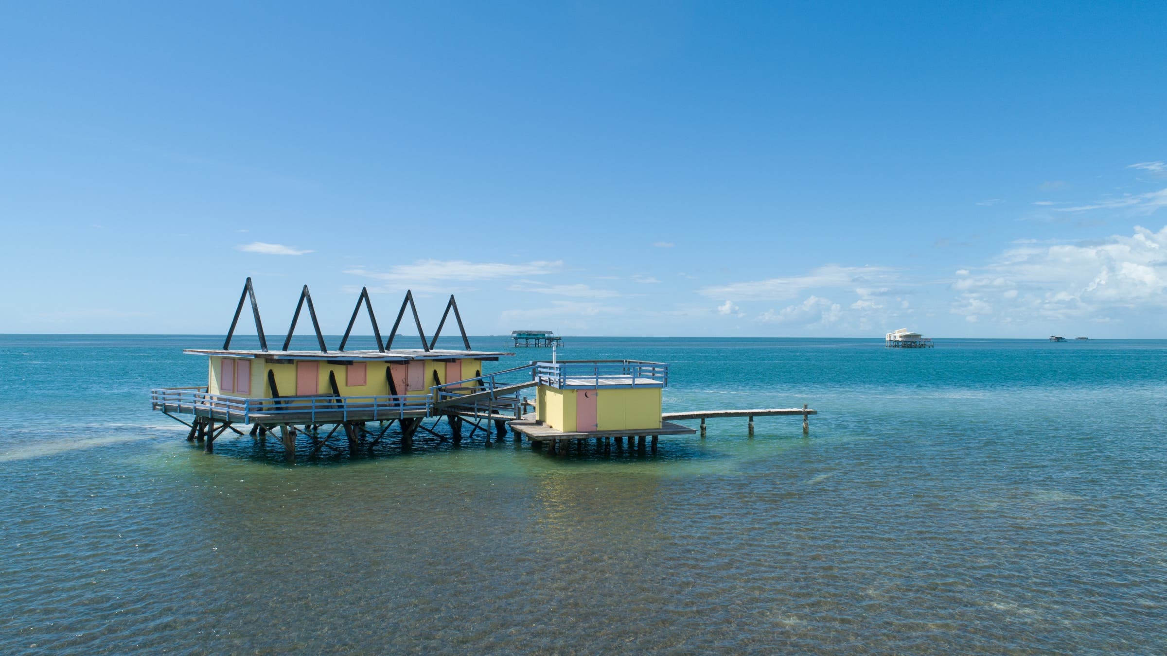 A building on stilts in shallow water.
