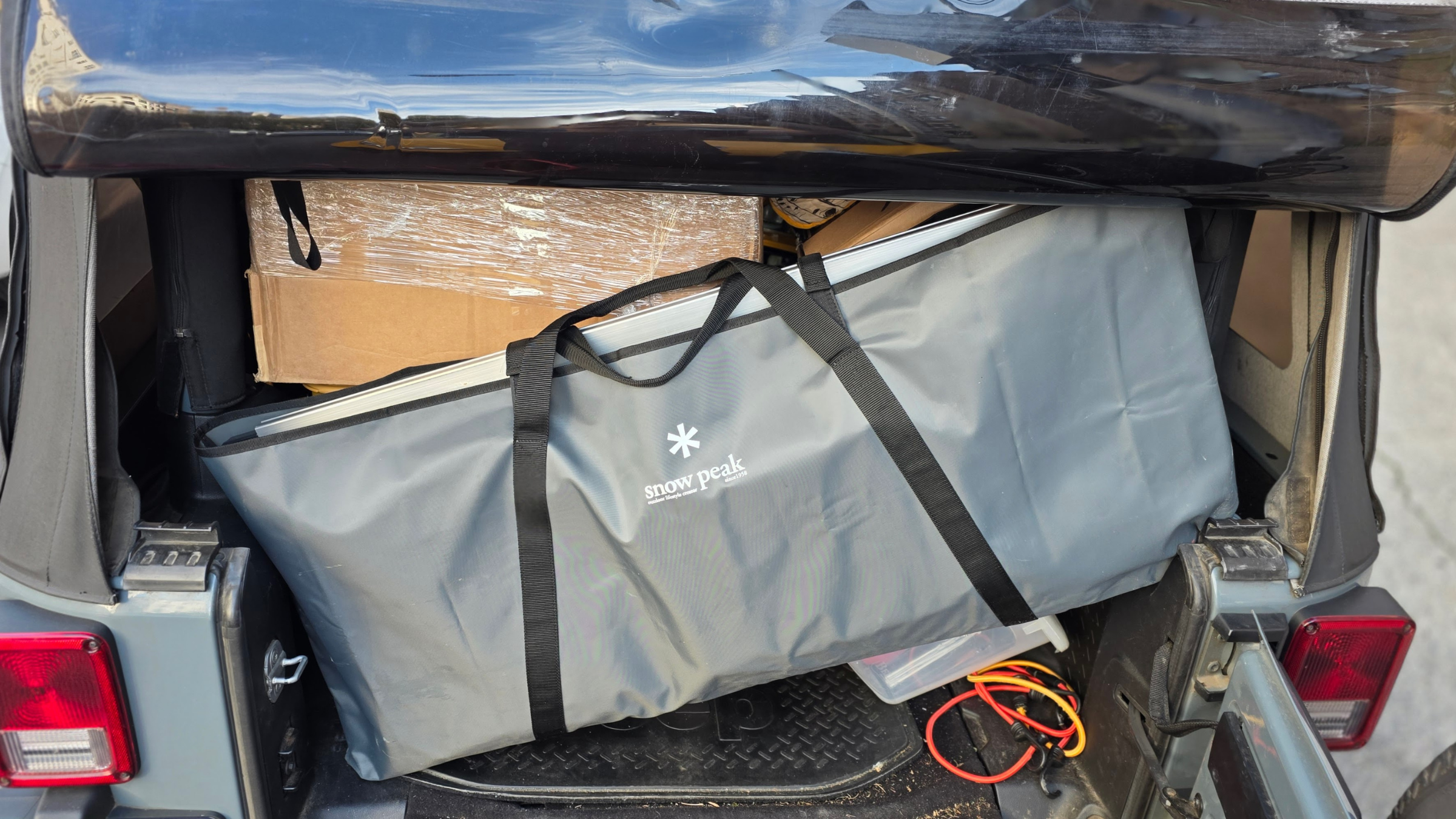 The Snow Peak IGT Camp Kitchen Starter Set packed in the back of a car trunk