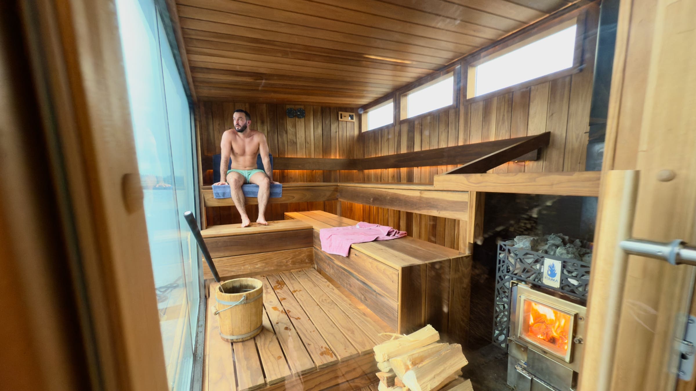 A man sits alone in a floating sauna.