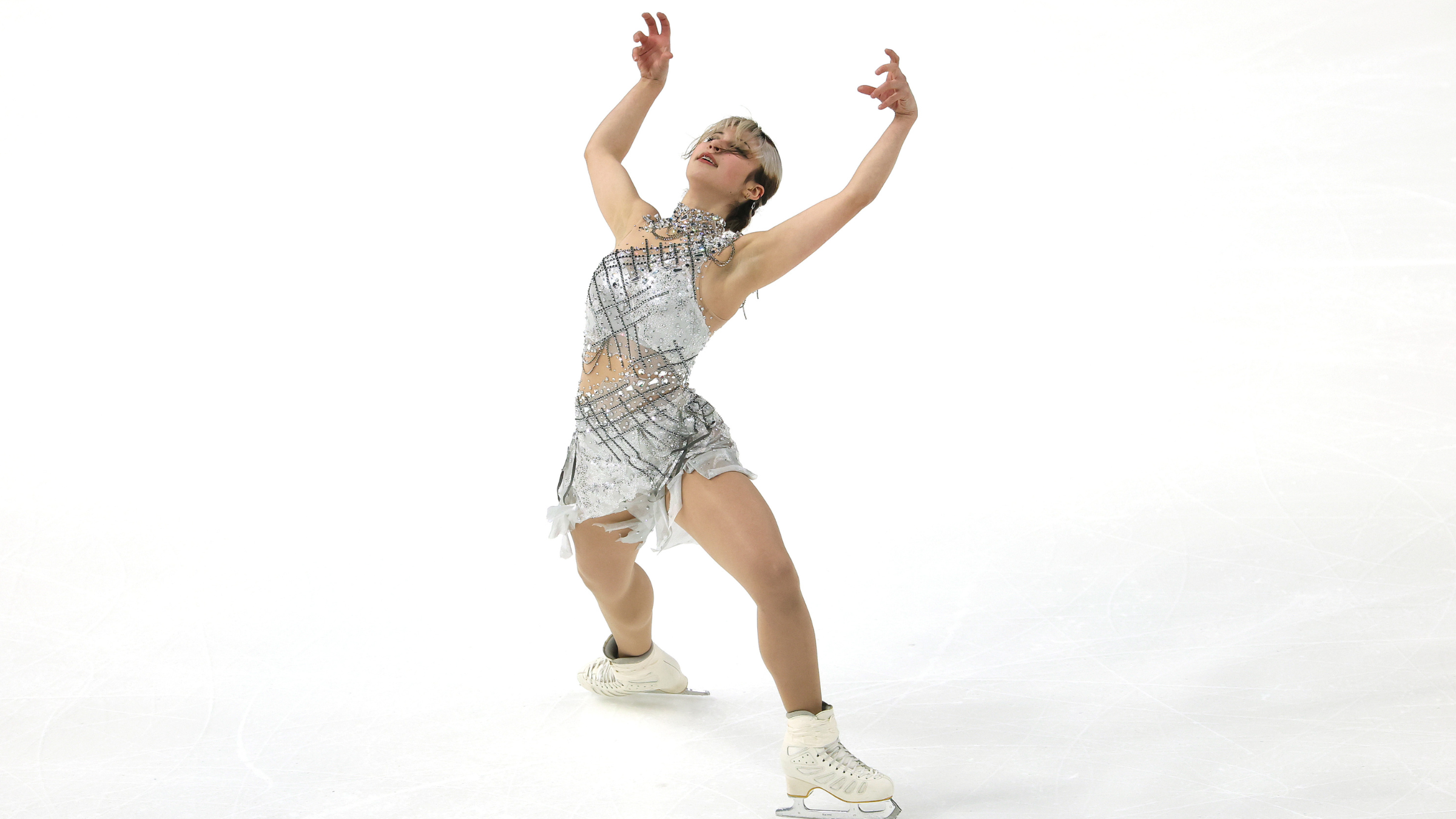 Skater Alysa Liu performs in a silver, diamond-encrusted costume designed with secure ornamentation to prevent deductions during complex jumps.
