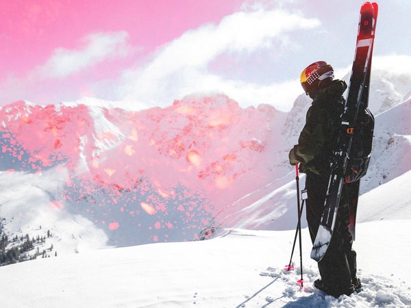 Skier Max Palm standing on snowy hill with Armada Antimatter skis on pack looking out over Silverton mountains